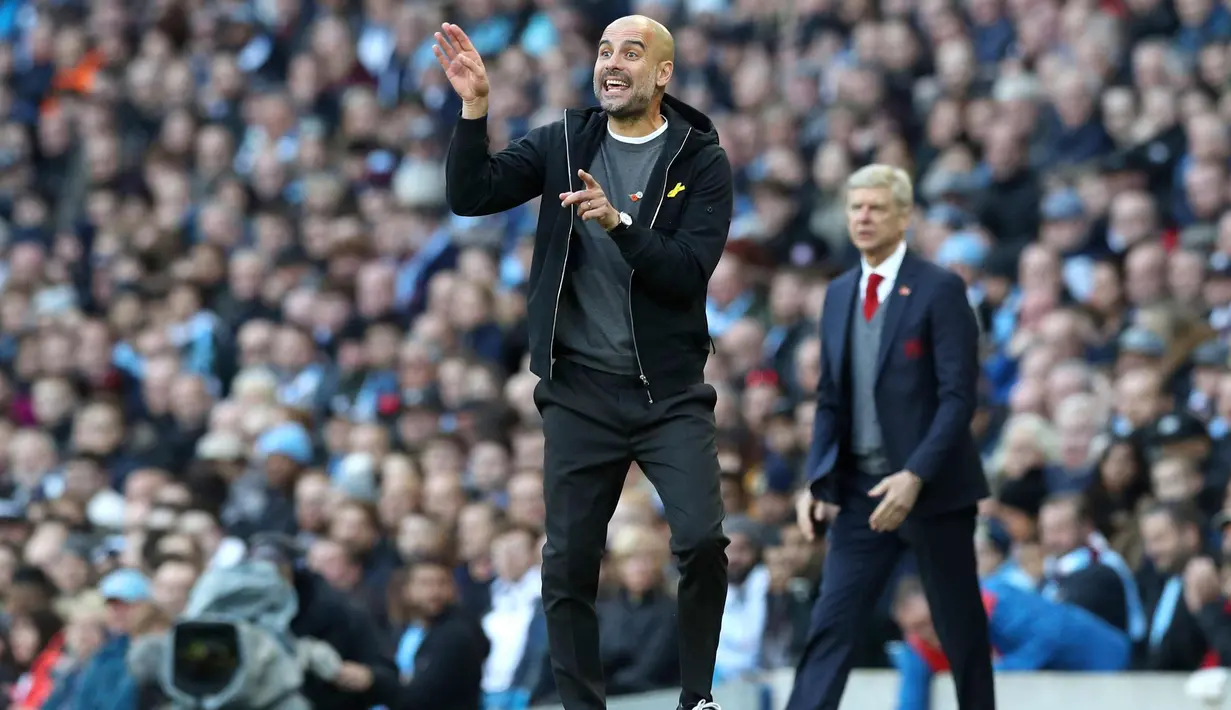 Pelatih Manchester City, Pep Guardiola memberi intruksi ke para pemainnya saat bertanding melawan Arsenal pada lanjutan Liga Inggris di di Stadion Etihad, Inggris, (5/11). City menang atas Arsenal dengan skor 3-1. (Martin Rickett / PA via AP)