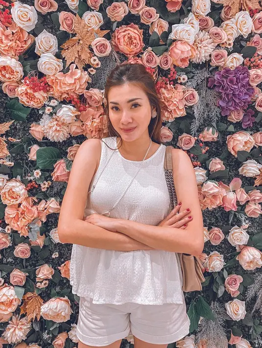Kenakan baju tanpa lengan dipadukan dengan celana pendek putih senada, penampilan Demmy Febriana simpel tapi tetap stylish. Rambut yang setengah diingat membuat pesonanya semakin terpancar. Senyuman manis seperti gula yang dipancarkannya ke kamera membuat auranya kian terpancar. (Liputan6.com/IG/@demmyfebriana)