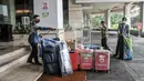 Petugas menyemprotkan cairan disinfektan pada barang-barang milik atlet kontingen DKI Jakarta saat tiba di Hotel Grand Cempaka Business, Jakarta, Kamis (14/10/2021). Nantinya para atlet ini akan menjalani tes swab PCR secara rutin tiap harinya serta tes malaria. (merdeka.com/Iqbal S. Nugroho)