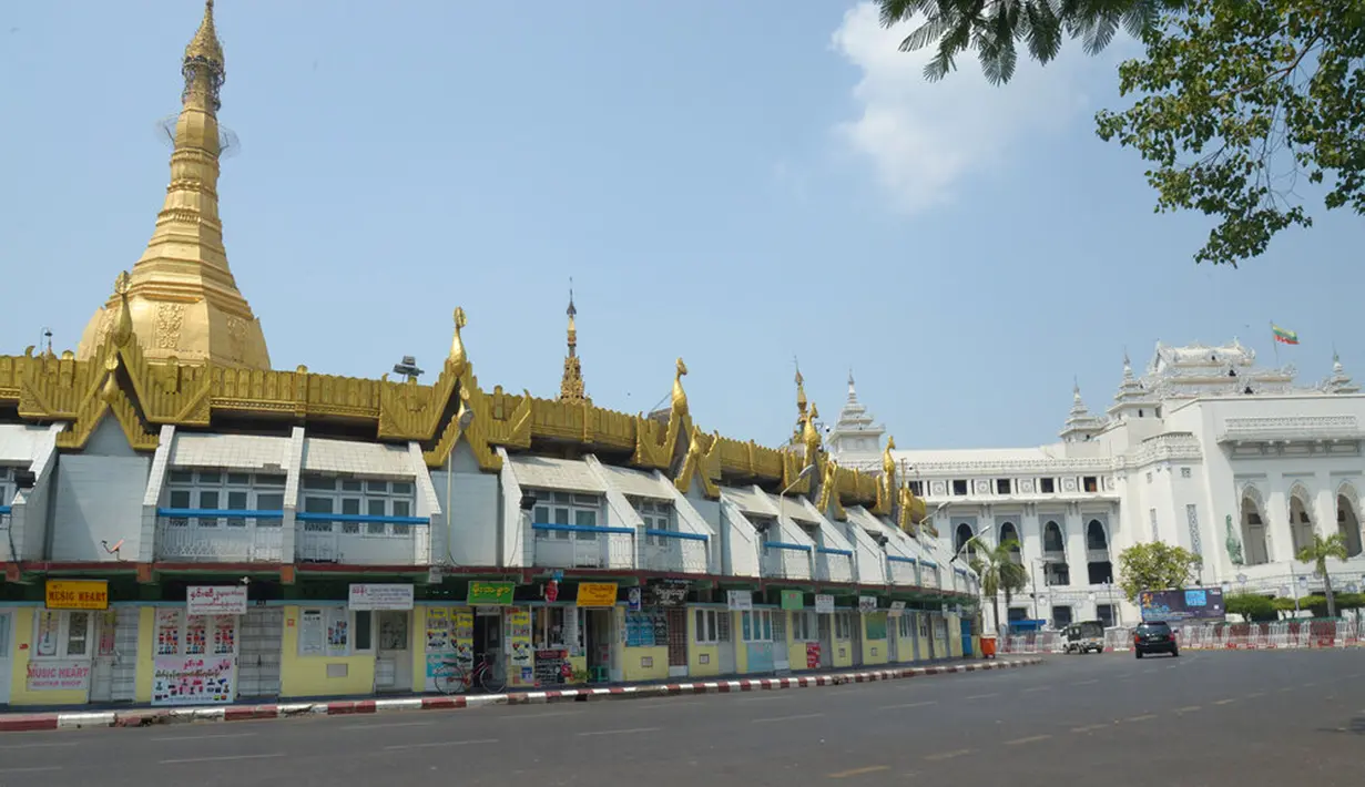 Sebuah kendaraan melaju melintasi jalanan yang kosong di sekitar Pagoda Sule, Yangon, Myanmar, Rabu (24/3/2021. Demonstran antikudeta mencoba taktik baru yang mereka sebut pemogokan 'diam', menyerukan orang-orang untuk tinggal di rumah dan menutup bisnis. (AP Photo)