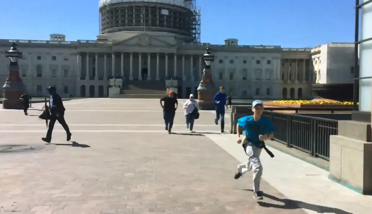 Sejumlah pengunjung yang berada di luar gedung Gedung Capitol, Washington DC, Amerika Serikat, mencari perlindungan pasca pascapenembakan di lokasi tersebut, Senin (28/3). Dalam insiden itu, pelaku dan pengunjung perempuan menderita luka. (REUTERS/WRC-TV)