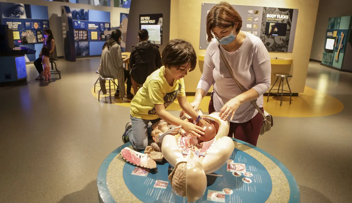 Seorang pekerja garis depan dan anaknya mengunjungi Science World di Vancouver, British Columbia, Kanada (23/7/2020). Science World Vancouver menawarkan tiket masuk gratis bagi para pekerja yang berjuang di garis depan melawan pandemi COVID-19 dan anggota keluarga mereka. (Xinhua/Liang Sen)