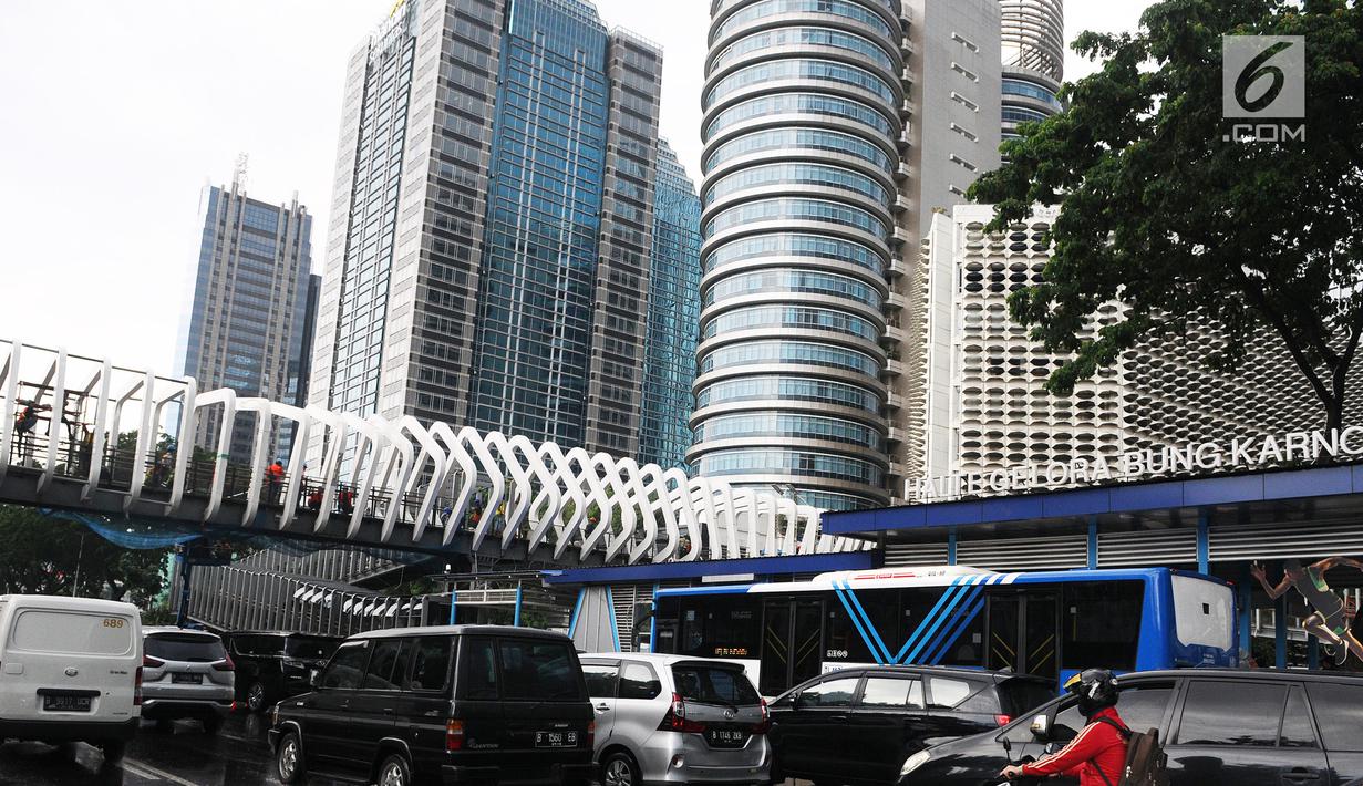 Kendaraan melintas jembatan penyeberangan orang (JPO) Gelora Bung Karno di kawasan Jenderal Sudirman, Jakarta, Sabtu (5/1). Revitalisasi tiga di kawasan Sudirman ditargetkan selesai pada pertengahan Januari 2019. (Liputan6.com/Herman Zakharia)