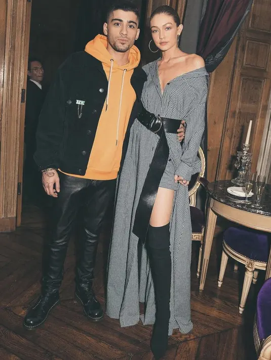 Sedangkan top model Gigi Hadid tampil mengenakan dress abu-abu bermotif dengan belt hitam sebagai pelengkap penampilan. Dan knee boots hitam.  (@gigihadid)