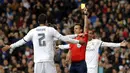 Wasit Estrada Fernandez memberikan kartu kuning kepada bek Real Madrid, Raphael Varane, pada laga La Liga Spanyol melawan Sevilla di Stadion Santiago Bernabeu, Madrid, Minggu (20/3/2016). Madrid menang 4-0 atas Sevilla. (EPA/Ballesteros)