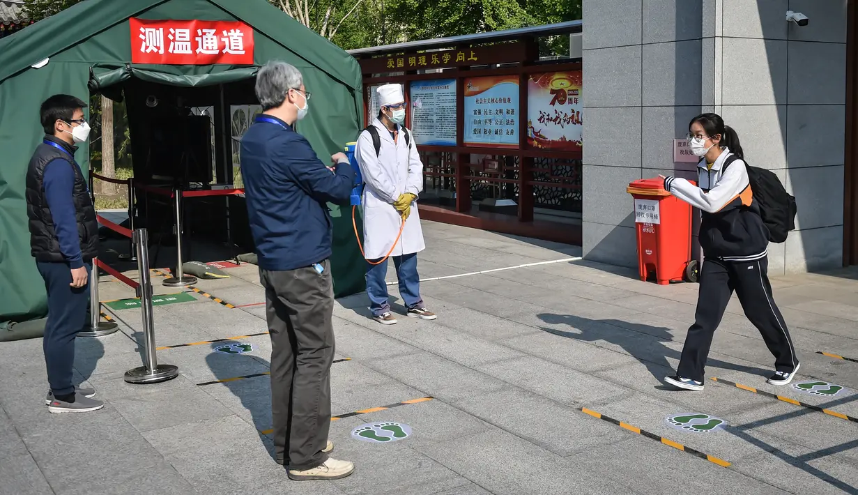 Seorang siswa akan melewati bagian pengukuran suhu di Sekolah Menengah Atas No. 161 Beijing, Beijing, China, Senin (27/4/2020). Sekolah menengah atas di Beijing memulai kembali kegiatan belajar di kelas untuk siswa tingkat akhir yang akan mengikuti ujian masuk perguruan tinggi. (Xinhua/Peng Ziyang)