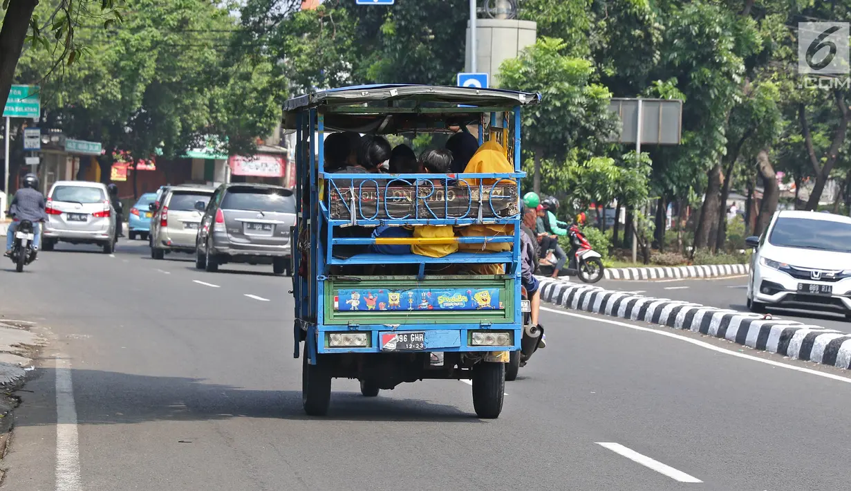 Sejumlah warga menaiki bak terbuka motor roda tiga menuju Kebun Binatang Ragunan di kawasan Jakarta, Minggu (9/6/2019). Masyarakat memanfaatkan motor roda tiga untuk bepergian saat libur lebaran karena dianggap lebih hemat biaya. (Liputan6.com/Herman Zakharia)