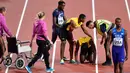 Pelari Jamaika, Usain Bolt mendapat perawatan usai terjatuh karena cedera di final 4x100 meter pada Kejuaraan Dunia Atletik, Sabtu (12/8). Pemegang rekor pelari tercepat di dunia itu terkapar di lintasan dan gagal melanjutkan lomba. (AP/Martin Meissner)