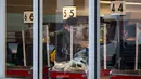 Seseorang yang mengenakan masker berdiri di belakang pembatas di konter kasir toko kelontong di Wilayah Brooklyn, New York, AS (12/11/2020). AS melaporkan 143.408 kasus baru COVID-19 pada Rabu (11/11), rekor peningkatan harian sejak merebaknya pandemi di negara itu. (Xinhua/Michael Nagle)