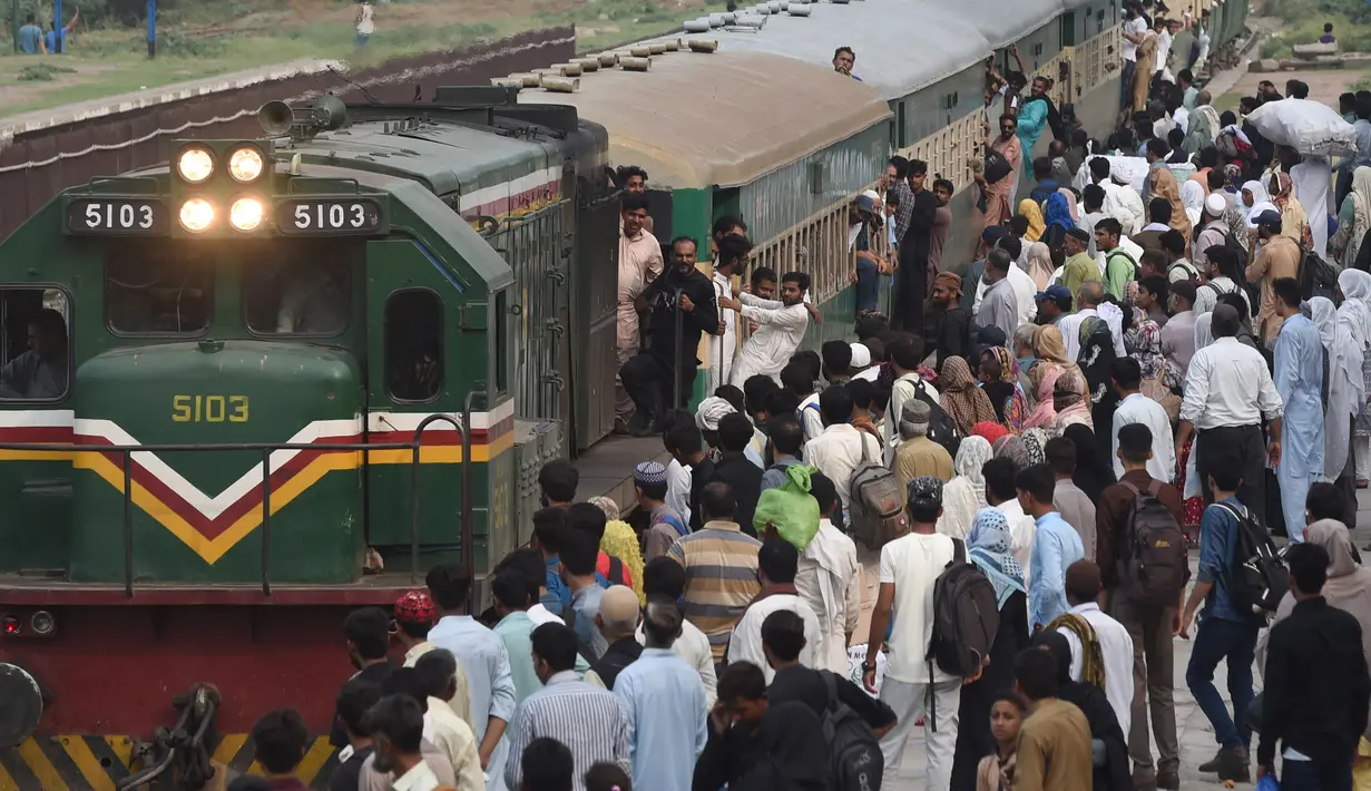 Warga Pakistan menaiki kereta api ke kampung halaman untuk merayakan Idul Adha, atau "Hari Raya Kurban," di Lahore, Pakistan, Kamis (7/7/2022). Selama hari raya, yang di sebagian besar tempat berlangsung selama empat hari, umat Islam menyembelih domba atau sapi dan membagikan sebagian dagingnya kepada orang miskin. (AFP/Arif Ali)