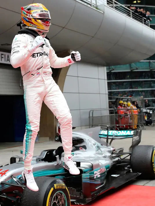 Pembalap Mercedes Lewis Hamilton berselebrasi di atas mobilnya setelah berhasil finis pertama pada balapan GP China di Sirkuit Internasional Shanghai, Minggu (9/4). Kemenangan ini merupakan podium pertama Hamilton pada musim 2017 (AP Photo/Toru Takahashi)