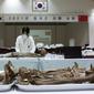 Anggota MND Agency for KIA Recovery and Identification (MAKRI) Korea Selatan menata jenazah tentara China yang tewas dalam Perang Korea di Incheon, Korea Selatan, Rabu (1/9/2021). Korea Selatan memulangkan 109 tentara China yang tewas dalam Perang Korea. (Jeon Heon-kyun/Pool Photo via AP)