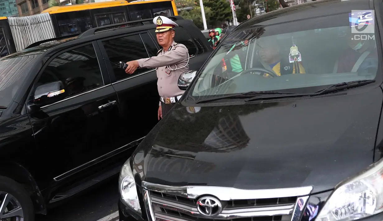 Petugas kepolisian mengatur lalu lintas di Senayan, Jakarta, Minggu (2/9). Untuk meminimalisasi kemacetan jelang penutupan Asian Games 2018, rekayasa lalu lintas dilakukan di sejumlah ruas jalan dari dan menuji Senayan. (Liputan6.com/Immanuel Antonius)