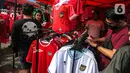 Suporter memilih jersey Timnas Indonesia jelang pertandingan AFF 2022 antara Indonesia melawan Thailand di Stadion Gelora Bung Karno, Jakarta, Kamis (29/12/2022). Atribut timnas Indonesia seperti kaos, syal, dan topi dijual dengan kisaran harga Rp35.000 hingga Rp75.000. (Liputan6.com/Faizal Fanani)