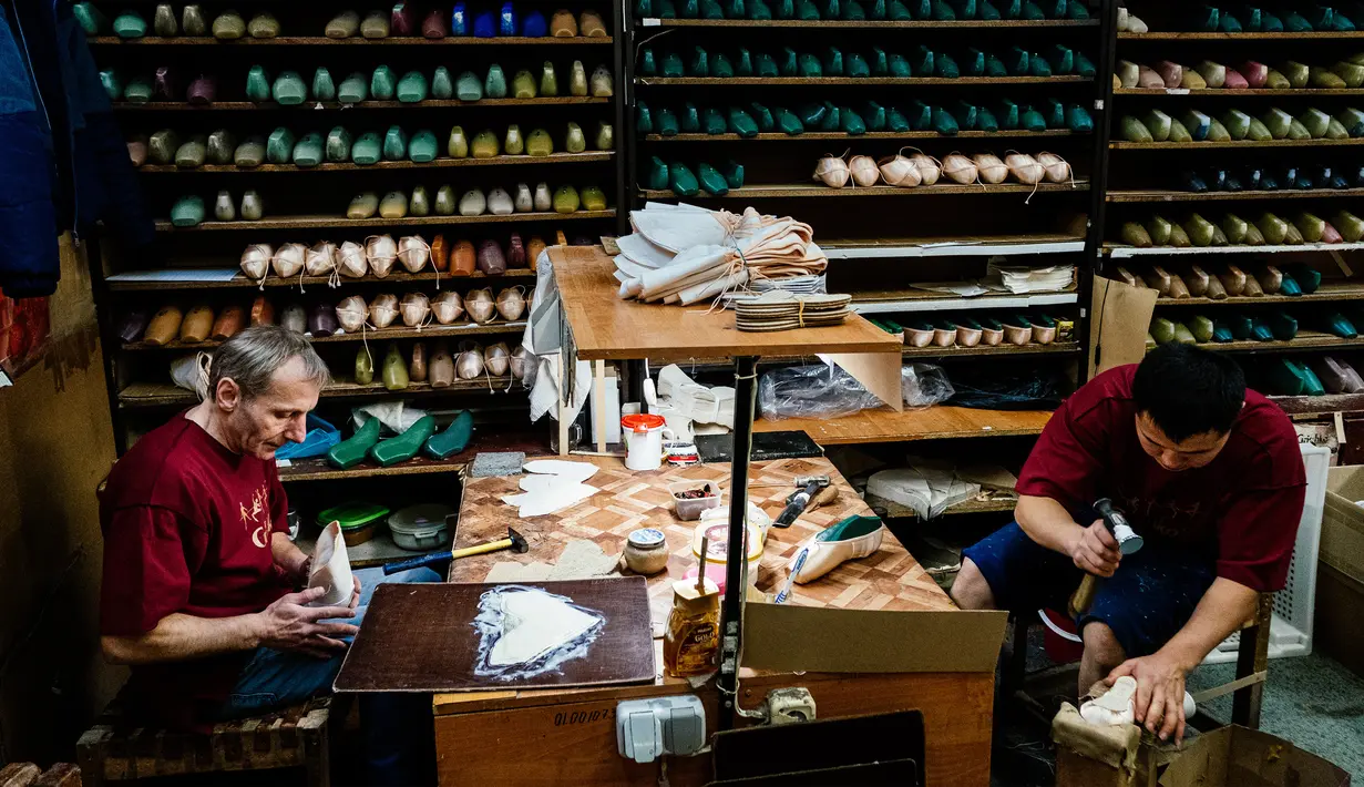 Para pekerja menyelesaikan pembuatan sepatu pointe di bengkel perusahaan Grishko, Moskow, Rusia, 25 Februari 2020. Sepatu buatan Grishko dijual ke seluruh dunia dan menghiasi panggung-panggung balet dunia. (Dimitar DILKOFF/AFP)