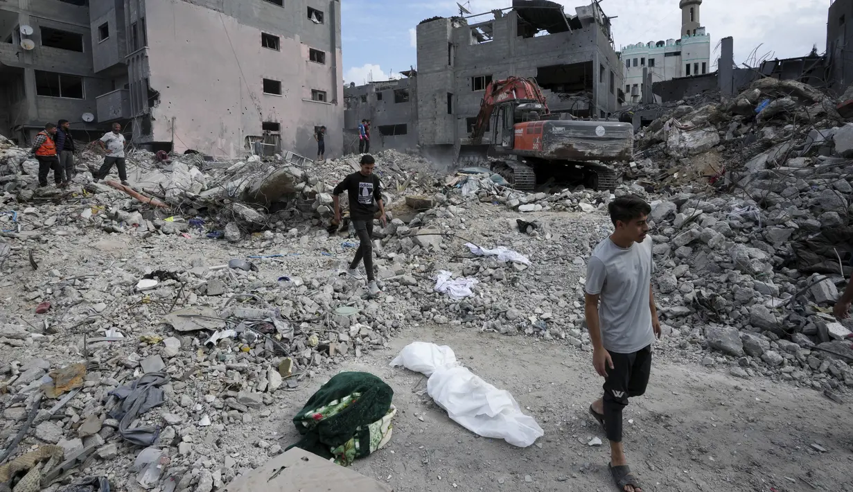 Reruntuhan demi reruntuhan terus terjadi di blok demi blok yang hancur. Baunya memuakkan. Setiap hari, ratusan orang mengais-ngais berton-ton puing dengan sekop, batang besi, dan tangan kosong. (AP Photo/Adel Hana)