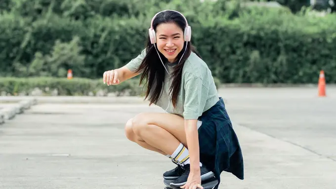 perempuan bahagia main skateboard