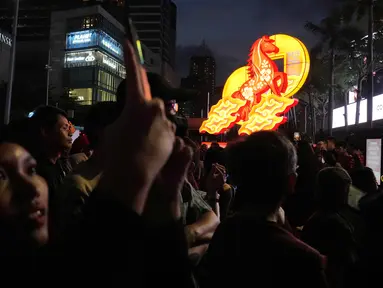 Seorang wanita menggunakan ponselnya untuk mengambil foto pertunjukan selama perayaan Tahun Baru Imlek 2577 Kongzili di kawasan Bundaran Hotel Indonesia (HI), Jakarta, Jumat 13 Februari 2026. Rangkaian Festival Imlek Jakarta 2026 dari jantung ibu kota, Bundaran Hotel Indonesia, Jakarta Pusat, resmi dibuka pada Jumat 13 Februari 2026 malam. (AP Photo/Dita Alangkara)