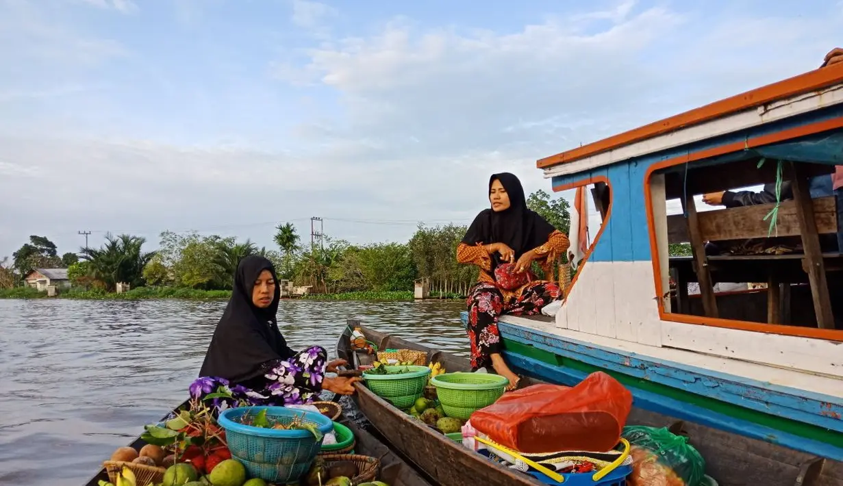 Para pedangan Pasar Terapung Lok Baintan menghampiri perahu kelotok pengunjung dengan sampan atau jukung (Liputan6.com/Pool/Kadek Arini)