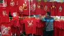 Seorang penjual pakaian yang bertemakan Imlek menunggu pembeli di Glodok, Jakarta, Rabu (18/01). Menjelang imlek, pedagang mulai marak menjual pernak-pernik Imlek yang berwarna serba merah. (Liputan6.com/JohanTallo)