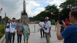 Fotografer taman, Joel Estrella menawarkan jasa foto kepada wisatawan di sebuah taman di Manila, Filipina (22/4). Estrella telah bekerja sebagai fotografer taman sejak tahun 1970. (AFP Photo/Ted Aljibe)