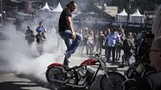 Seorang pria melakukan aksi berdiri diatas motor saat acara 6th Morzine-Avoriaz Harley Days 2017, Morzine (15/7). Sekitar 10.000 sepeda motor dan 30.000 bikers dari seluruh Eropa berkumpul untuk mengikuti acara ini. (AFP Photo/Jean-Philippe Ksaizek)