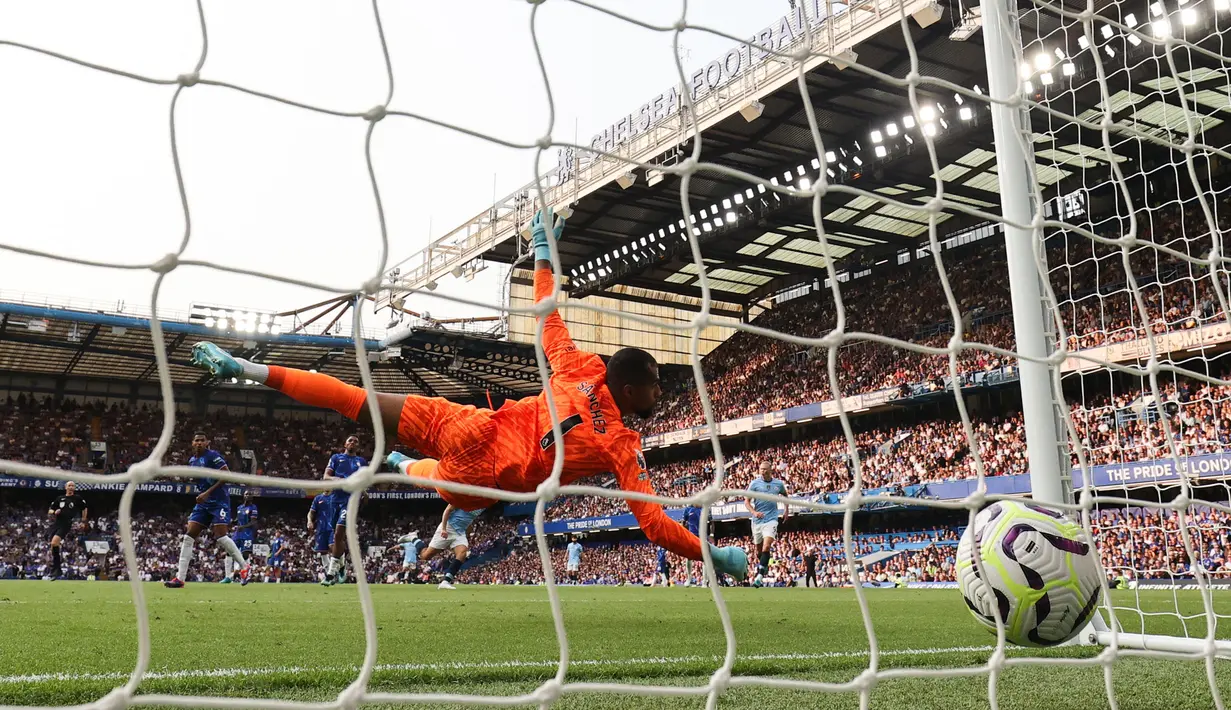 Kiper Chelsea, Robert Sanchez gagal menghalau bola tendangan dari pemain Manchester City, Mateo Kovacic pada laga Liga Inggris 2024/2025 di Stamford Bridge, London, Inggris, Minggu (18/08/2024) malam WIB. (AFP/Adrian Dennis)