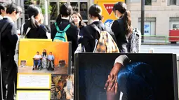 Anggota dari Amnesty International menjelaskan tentang situasi perang saudara yang melanda Aleppo, Suriah kepada para siswa di kampus Universitas Meiji di Tokyo, Jepang (18/11). (AFP/Toshifumi Kitamura)