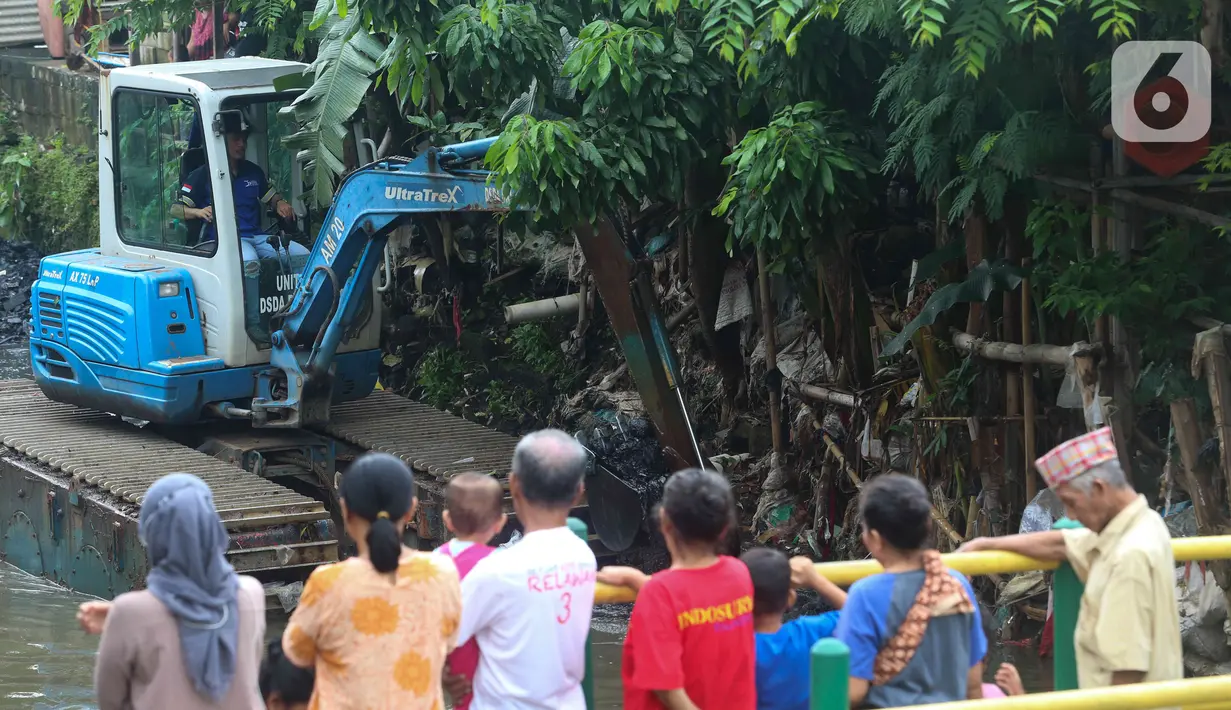Warga mengamati alat berat yang dioperasikan untuk pengerukan di Kali Mampang, Pondok Jaya, Sabtu (19/2/2022). Pengadilan Tata Usaha Negara (PTUN) Jakarta mengabulkan gugatan warga pada 19-21 Februari 2021 terkait program pencegahan banjir yang dilakukan Pemprov DKI. (Liputan6.com/Herman Zakharia)
