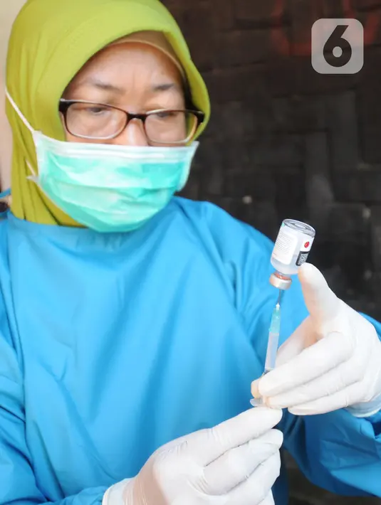 Paramedis bersiap menyuntikkan vaksin COVID-19 secara drive thru di GOR Pajajaran, Kota Bogor, Jawa Barat, Rabu (17/3/2021). Kegiatan ini diselenggarakan oleh Halodoc, Gojek, dan Pemkot Bogor. (merdeka.com/Arie Basuki)