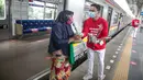 Petugas KAI Commuter (kanan) memberikan bunga dan healthy kit kepada perempuan pengguna KRL di Stasiun Jatinegara, Jakarta, Selasa (22/12/2020). Kegiatan tersebut dalam rangka memperingati Hari Ibu yang jatuh setiap tanggal 22 Desember. (Liputan6.com/Faizal Fanani)