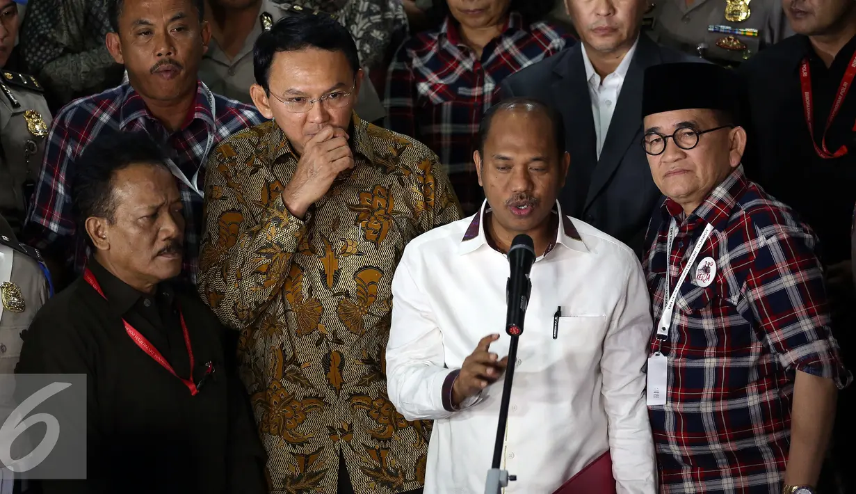 Usai diperiksa Bareskrim, Ahok terlihat hanya berdiri di belakang Ketua Tim Kuasa Hukum Sirra Prayuna, Jakarta, Selasa (22/11). Selama konferensi pers, muka Ahok terlihat masam dan dia terlihat serius. (Liputan6.com/Johan Tallo) 