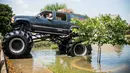 Truk monster menerobos genangan air saat membantu warga yang menjadi korban Badai Harley di Port Arthur, Texas, AS (1/9). Truk raksasa ini menjadi salah satu kendaraan yang diandalkan usai Badai Harley menghantam Texas. (AFP Photo/Emily Kask)