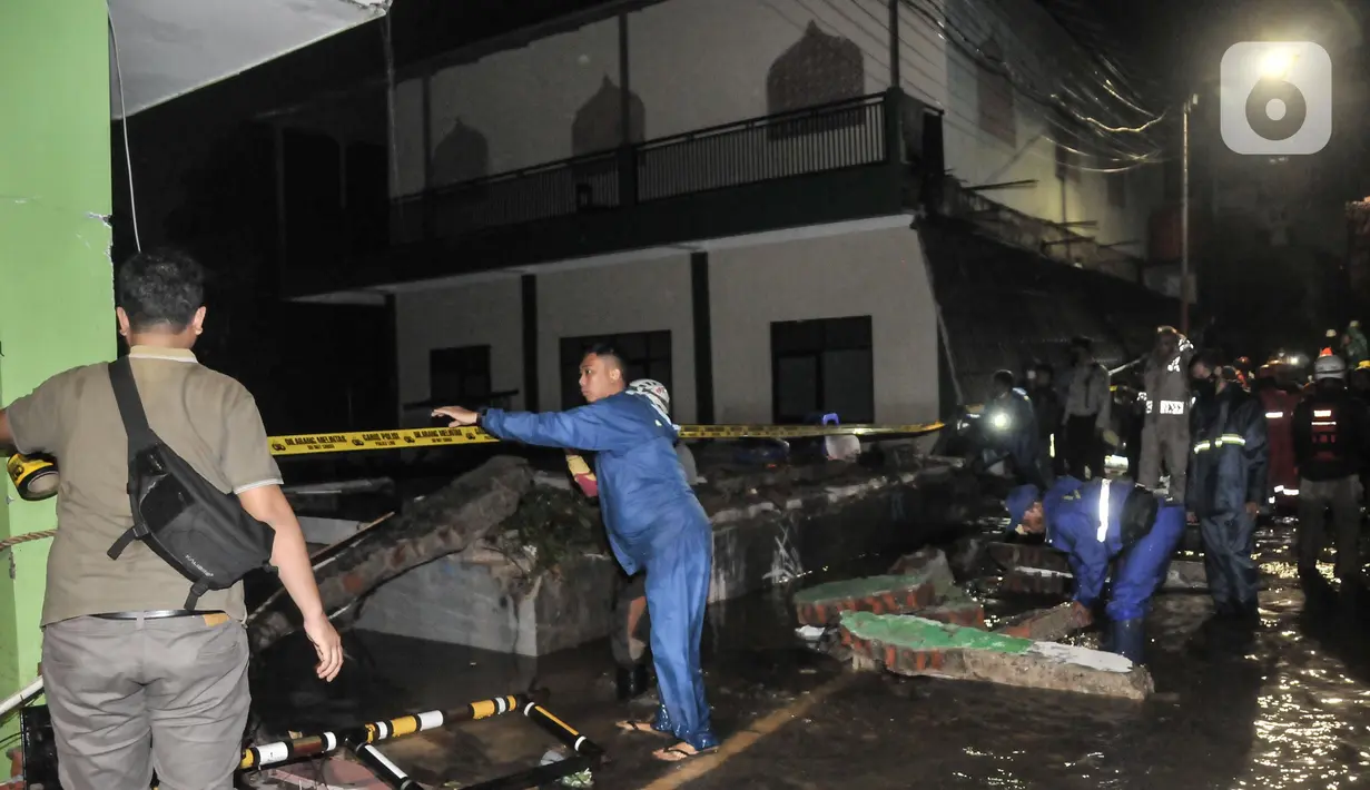 Petugas gabungan saat mengevakuasi reruntuhan pasca robohnya tembok bangunan akibat terjangan banjir di Madrasah Tsanawiyah (MTs) Negeri 19 di Jalan Pinang Kalijati, Pondok Labu, Cilandak, Jakarta Selatan, Kamis (6/10/2022). Peristiwa robohnya tembok sekolah bersamaan dengan hujan deras pada sore tadi tersebut diakibatkan oleh terjangan banjir yang menyebabkan tiga siswa tewas dan dua lainnya luka-luka. (merdeka.com/Iqbal S. Nugroho)