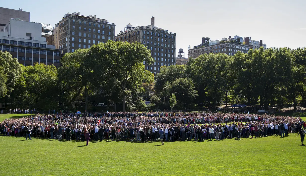 Ribuan orang berkumpul untuk membentuk simbol perdamaian raksasa di New York Central Park , Selasa (6/10). Kegiatan yang diprakarsai janda Lennon, Yoko Ono itu menandai ulang tahun John Lennon ke-75. (REUTERS/Mike Segar)