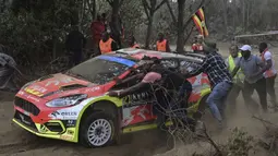 Sejumlah penonton membantu mendorong mobil Ford Fiesta MkII milik tim reli Republik Ceska yang dikendarai oleh Martin Prokop dan Zdenek Jurka karena mogok dalam ajang Safari Rally Kenya 2022 yang berlangsung di kota tepi danau Naivasha pada 24 Juni 2022. (AFP/Tony Karumba)