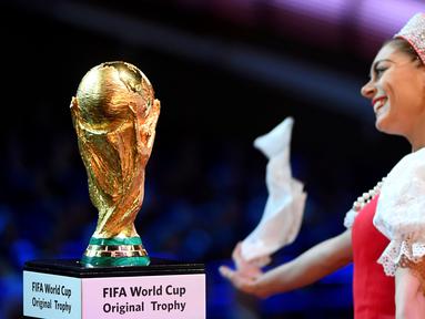Seorang penari Balet Rusia tampil dekat trofi Piala Dunia saat undian Piala Dunia 2018 di State Kremlin Palace, Moscow, (1/12/2017). Piala Dunia 2018 berlangsung sejak 14 Juni hingga 15 Juli 2018 di Rusia. (AFP/Alexander Nemenov)