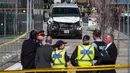 Aparat polisi berdiri dekat sebuah van yang menabrak para pejalan kaki di persimpangan utama di pinggiran utara Toronto, Kanada, Senin (23/4). Sembilan orang tewas dan 16 lainnya terluka dalam insiden itu. (Aaron Vincent Elkaim/The Canadian Press via AP)