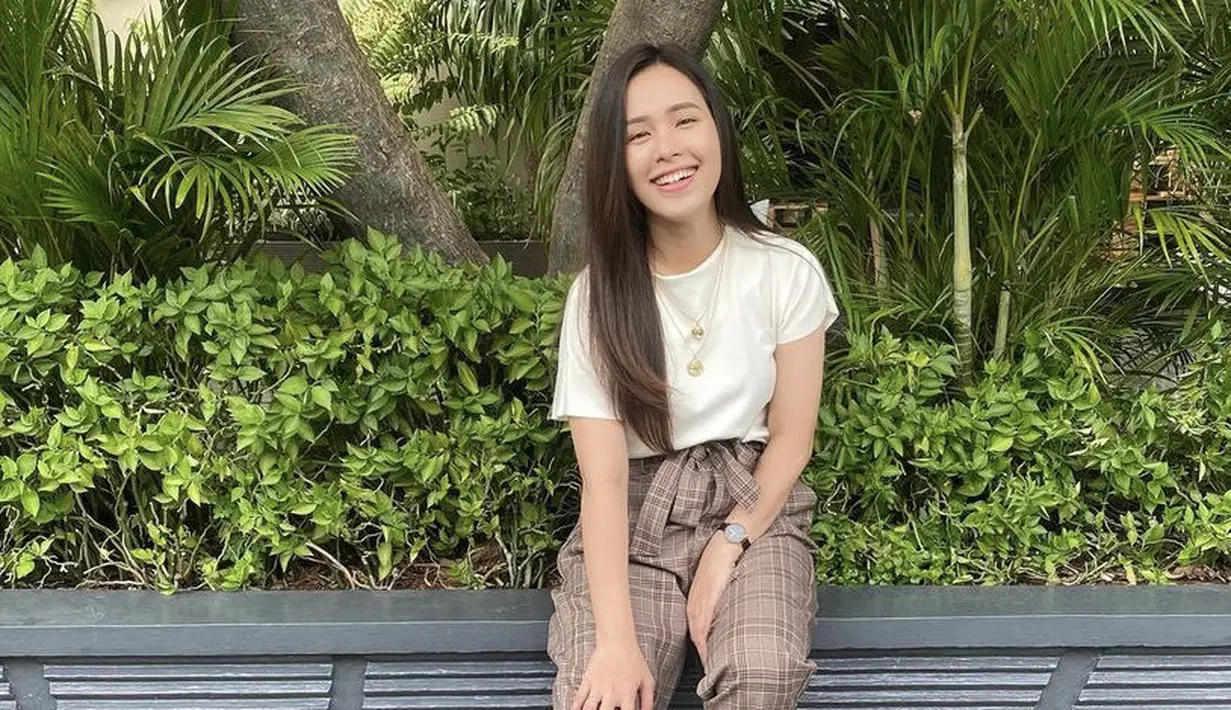 Ibu tiga anak ini tampil dengan tshirt putih dipadukan celana kotak-kotak dengan detail pita di bagian pinggang. Dipadukan sepatu beigenya. (@ladykjaernett)