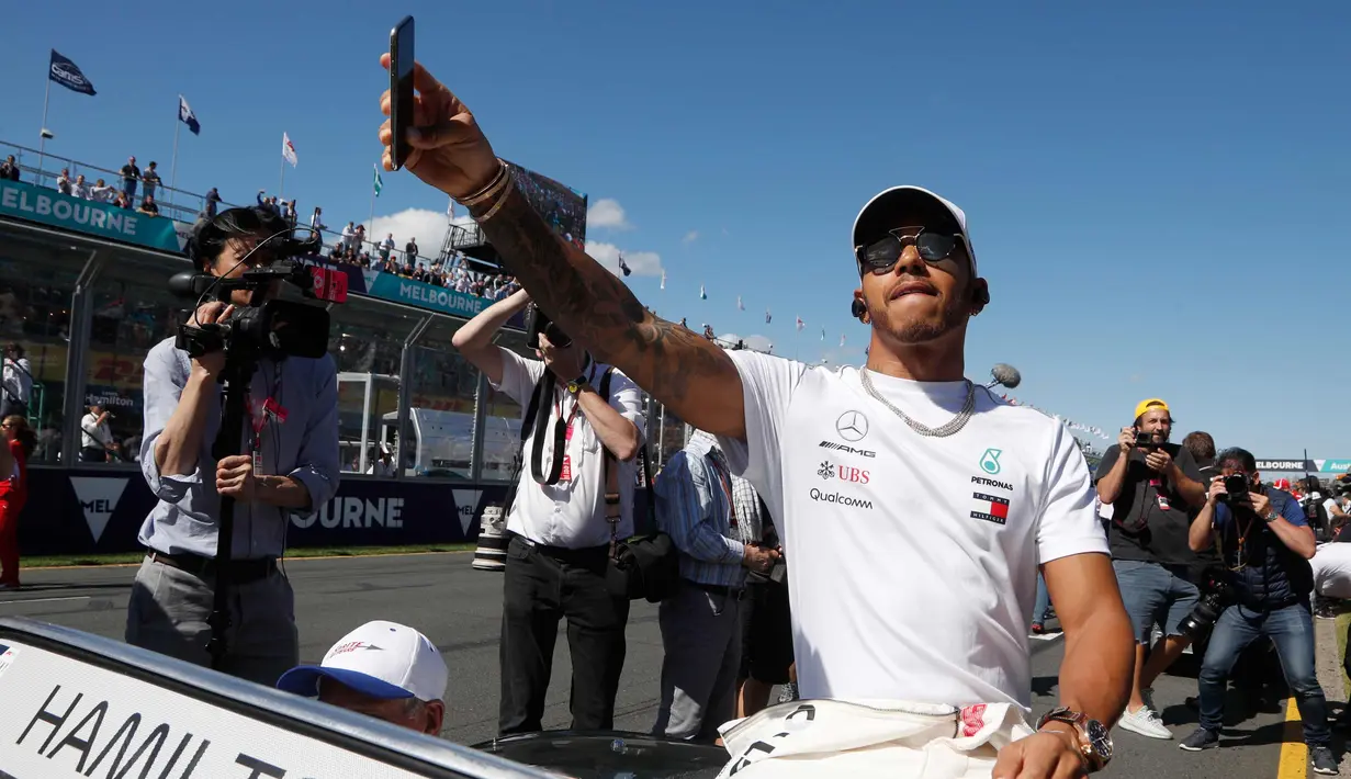 Pembalap dari tim Mercedes, Lewis Hamilton mengikuti parade jelang balapan pertama musim ini di GP F1 Australia di Melbourne, Australia, (25/3). Hamilton menempati posisi start terdepan dalam Grand Prix Australia. (AP Photo/Asanka Brendon Ratnayake)