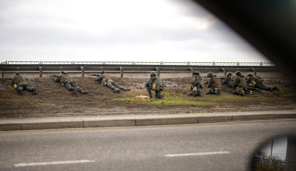 Tentara Ukraina mengambil posisi di bawah jembatan saat melakukan tembakan di dalam Kota Kiev, Ukraina, Jumat (25/2/2022). Rusia menekan invasinya sampai ke pinggiran Kiev usai melepaskan serangan udara di kota-kota dan pangkalan militer serta mengirimkan pasukan dan tank.(AP Photo/Emilio Morenatti)