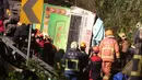 Tim SAR berusaha mengevakuasi bangkai bus pariwisata yang terbalik di ruas jalan dekat Taipe, ibu kota Taiwan, Selasa (14/2). Bus dilaporkan telah berusia 19 tahun dan dimiliki sebuah agen wisata yang melayani tur di seluruh Taiwan. (AP Photo)