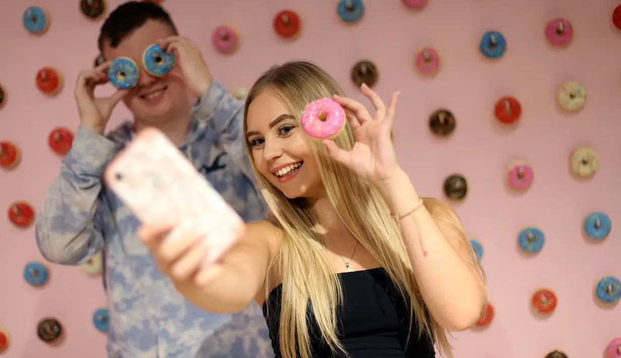 Pengunjung berswafoto ketika mengunjungi The Selfie Factory di pusat perbelanjaan Westfield, London pada 11 September 2019. Dengan membayar 10 poundsterling, pengunjung bisa berfoto di ruangan yang berlatar unik dan menggemaskan. (Isabel INFANTES / AFP)