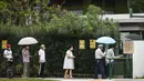 Para pemilih mengenakan masker dan menerapkan jaga jarak aman saat akan memberikan suara dalam pemilu di TPS Sekolah Dasar Alexandra, Singapura, Jumat (10/7/2020). Pemilu di tengah pandemi COVID-19, warga Singapura memberikan suaranya dengan mengenakan masker dan sarung tangan plastik. (AP Photo)