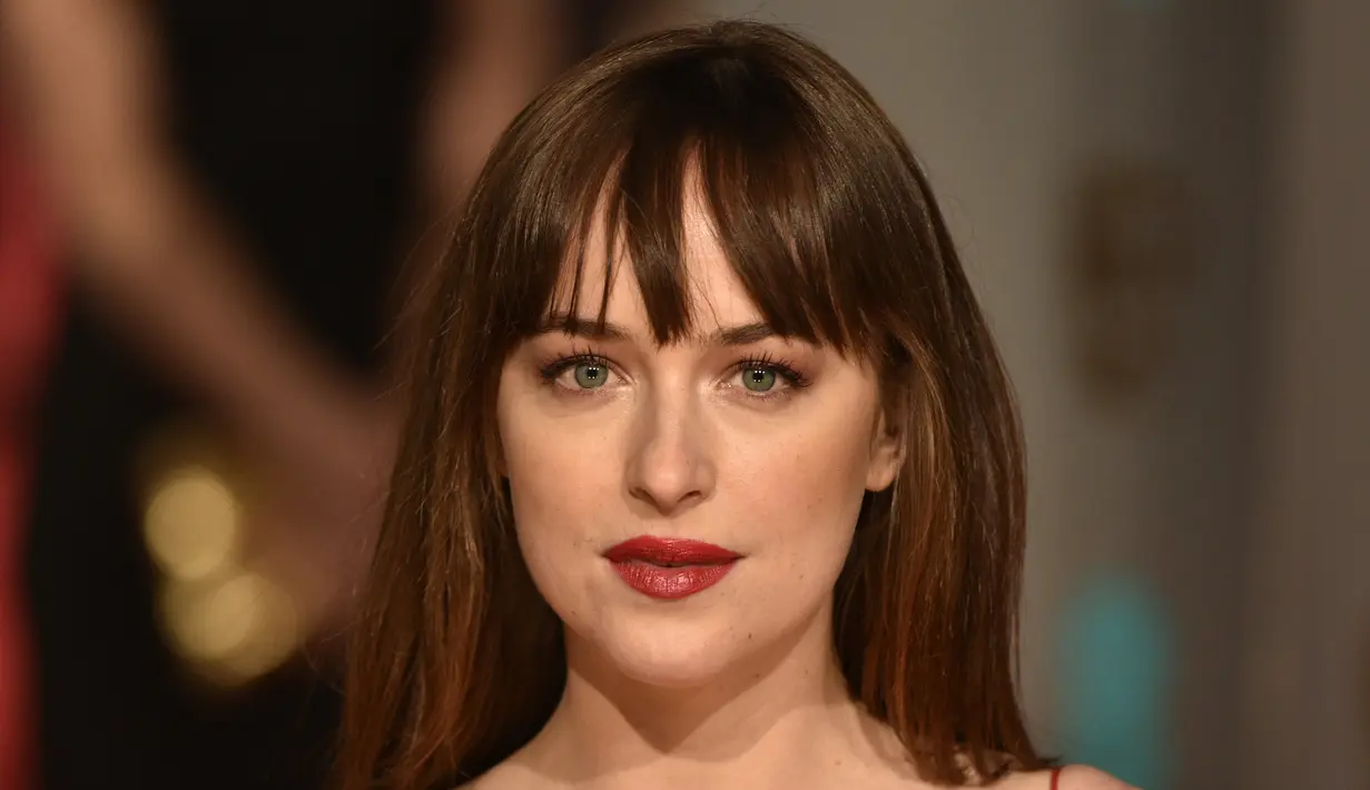 Aktris AS, Dakota Johnson berpose di red carpet ajang British Academy of Film and Television Arts (BAFTA) 2016 di London, Minggu (14/2). Nominator kategori Rising Star itu tampil dengan sapuan make up tipis dan tanpa memakai akesoris. (AFP/NIKLAS HALLE'N)