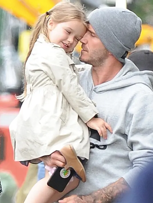 Harper Beckham dan ayahnya saat berada di bandara LAX pada 12 Juli 2015. Harper tampil manis dengan jas jaketnya. (harperbeckhamfashion)