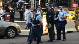 Polisi berjaga di tempat kejadian setelah seorang pria menikam seorang wanita dan berusaha menikam orang lain di pusat kota Sydney (13/8/2019). Polisi mengatakan wanita itu dalam kondisi stabil tidak mengalami luka. (AFP Photo/Saeed Khan)