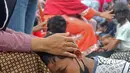 Seorang ibu memegang kepala anaknya saat di Kelurahan Duri Pulo, Jakarta, Rabu (21/12/2021). Aksi mencuci kaki ibu secara massal yang diikuti 500 peserta itu bertujuan untuk meningkatkan rasa cinta kasih kepada ibu dan dilakukan dalam rangka memeriahkan Hari Ibu. (Liputan6.com/Herman Zakharia)