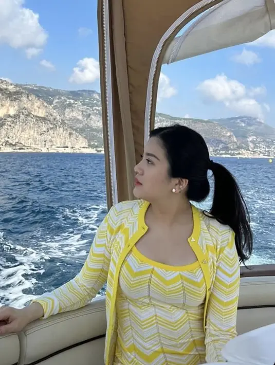 Rambutnya diikat ke belakang, dengan makeup flawless mengaplikasikan lipstik merahnya. Serta perhiasan anting dan cincinnya.  [@valenciatanoe]