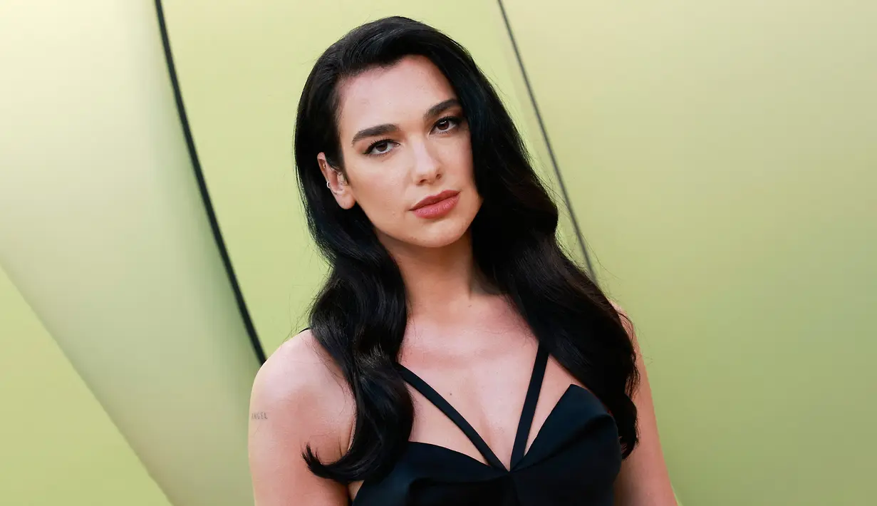 <p>Dua Lipa berpose saat tiba untuk peragaan busana Versace Fall/Winter 2023 di Pacific Design Center, West Hollywood, California, Amerika Serikat, 9 Maret 2023. Penyanyi sekaligus penulis lagu asal Inggris ini tampil memukau dengan tampilan Hollywood kuno. (Michael Tran/AFP)</p>
